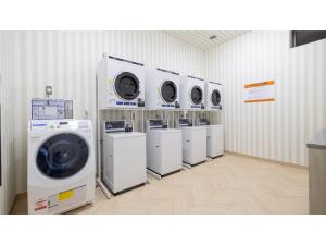 a laundry room with a row of washers and dryers at Hotel Taiyo Noen Saijo - Vacation STAY 26770v in Saijo