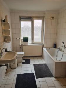 ein Badezimmer mit Badewanne, Toilette und Waschbecken in der Unterkunft Three bedroom lovely apartment in Oosterbeek + 4 Fotos