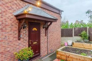a brick house with a brown door with lights on it at Cozy One-Bed Apartment in Nottingham in Nottingham +6 photos