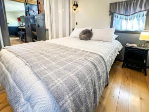 a bedroom with a bed with a gray and white blanket at Paw Railway Getaway in Port Angeles