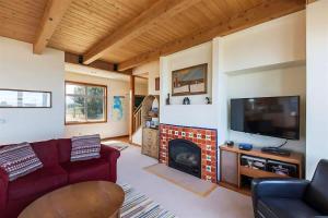 Una sala de estar con chimenea y televisión. en Sq Dungeness Bay Beach House, en Sequim