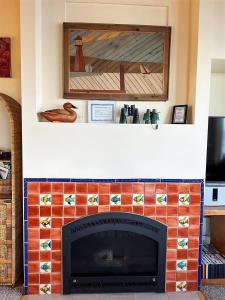 una sala de estar con chimenea y una pintura encima. en Sq Dungeness Bay Beach House, en Sequim
