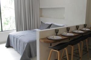 a bedroom with a bed and two stools with plates and wine glasses at Minimalist Terracota Chapu in Guadalajara +31 photos
