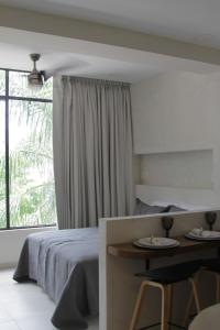 a bedroom with a bed and a table and a window at Minimalist Terracota Chapu in Guadalajara