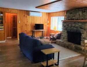 a living room with a blue couch and a stone fireplace at Burke's Place in Wawona