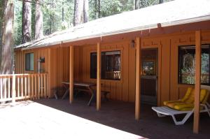 a cabin in the woods with a porch and a table at Burke's Place in Wawona