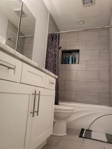 a bathroom with a tub and a toilet and a sink at The Duke's Castle with Garage & Fast Internet in Dallas +33 photos