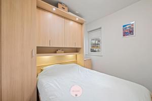 Casa Tropezina by BLOSS familieappartement met terras في أوستند: غرفة نوم صغيرة مع سرير ودواليب خشبية