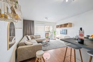 Casa Tropezina by BLOSS familieappartement met terras في أوستند: غرفة معيشة بها أريكة وطاولة