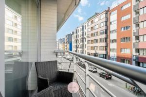 Casa Tropezina by BLOSS familieappartement met terras في أوستند: بلكونه مطله على شارع ومباني