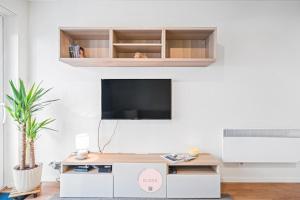 Casa Tropezina by BLOSS familieappartement met terras في أوستند: غرفة معيشة مع تلفزيون على جدار أبيض