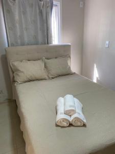 a bed with towels sitting on top of it at Pousada Le Sorelle ap04 in Rosário do Sul