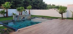 a swimming pool in a backyard with a wooden deck at Halte Provence - 2 chambres - Piscine - Salle de bain privée - Parking gratuit in Gignac-la-Nerthe