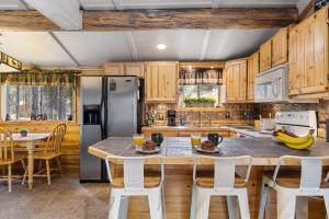 una cocina con armarios de madera y una gran isla con taburetes. en Hayloft Hollow, en Island Park