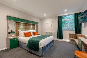 a bedroom with a large bed with a green headboard at Springbank Manor in Darwen