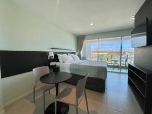 een hotelkamer met een bed, een tafel en stoelen bij RN Studio Premium Max Rev in Maceió