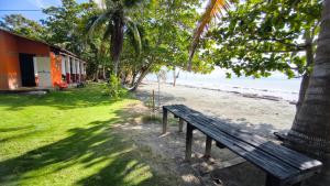 a wooden bench sitting next to a beach at Tiki Lounge Necoclí in Necoclí