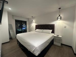 - une chambre avec un grand lit et deux lampes suspendues dans l'établissement Exclusivo Apto 2 habitaciones aire acondicionado cerca Oakland Place Z 10, à La Aurora 95 autres photos
