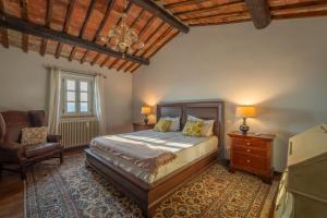 a bedroom with a bed and a chair at Villa Olivo by Great Stays in Città della Pieve +67 photos