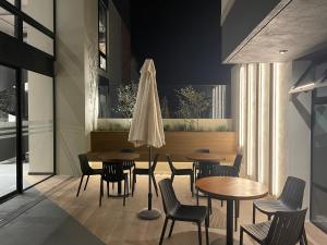 - un restaurant avec des tables, des chaises et un parasol dans l'établissement Exclusivo Apto 2 habitaciones aire acondicionado cerca Oakland Place Z 10, à La Aurora