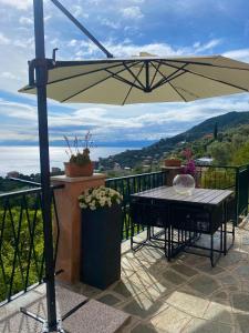 een patio met een tafel en een parasol bij casa lella home in Recco