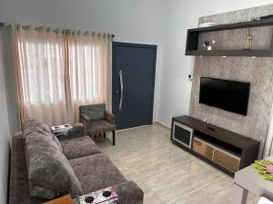 a living room with a couch and a television at Casa em Toledo 1 suíte e 2 quartos confortável in Toledo