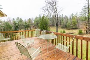 un patio con tavolo e sedie su un ponte di legno di Carrie's Cottage a Rogers