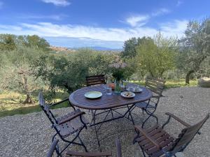 a wooden table with chairs and flowers on it at Villa Ceppeto, Best Of Tuscany at Brand New Nest in Monte San Savino