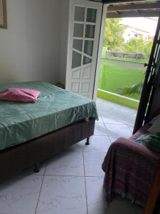 a bedroom with a bed and a sliding glass door at Casa Verde Stella Maris in Salvador +23 photos