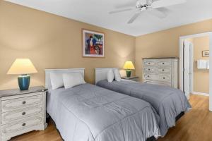 a bedroom with two beds and a ceiling fan at 2 Bedroom Golf Villa in Pawleys Island in Pawleys Island +16 photos