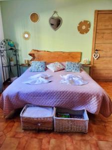 a bedroom with a bed with purple sheets and baskets at El Patio in Darnius