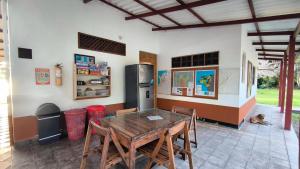 a kitchen with a wooden table and a refrigerator at Tiki Lounge Necoclí in Necoclí