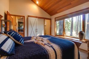 a bedroom with a bed and a large window at 15th Fairway Retreat in Sisters