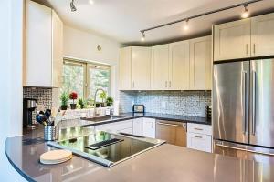 a kitchen with white cabinets and a stainless steel refrigerator at Sqe Mystic Grove in Sequim