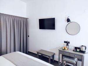 a hotel room with a bed and a desk with a mirror at Lefka Ori - Agia Galini in Agia Galini