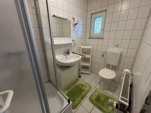a bathroom with a sink and a toilet and a shower at Haus Mariechen in Hooksiel +57 photos