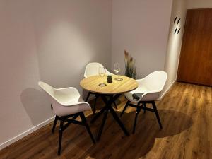 a table with chairs and wine glasses on it at Fächerlofts Black Forest Terrasse 40qm Studio WLAN - Messe Karlsruhe in Durmersheim