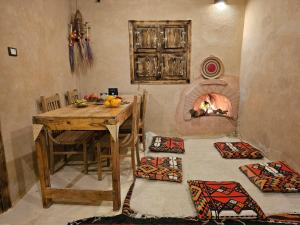 a dining room with a table and a fireplace at Paradise in a palm forest with epic pool in siwa oasis