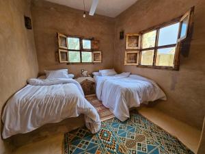 a bedroom with two beds and a window at Paradise in a palm forest with epic pool in siwa oasis +9 photos