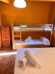 2 Etagenbetten in einem Zimmer mit einem Handtuch in der Unterkunft Finca Rural con piscina en Calera y Chozas in Talavera de la Reina