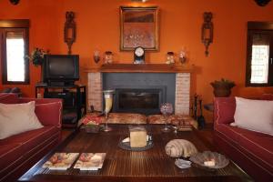 ein Wohnzimmer mit Tisch und Kamin in der Unterkunft Finca Rural con piscina en Calera y Chozas in Talavera de la Reina