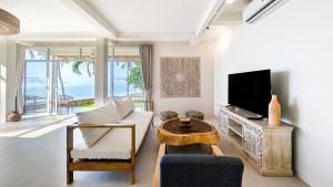 a living room with a couch and a tv at Happy Home kpg in Koh Phangan