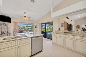 a large kitchen with white cabinets and a ceiling fan at LPC1140 in Punta Gorda