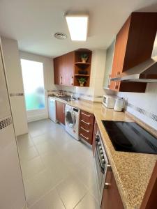 ビリャホヨサにあるParaiso Costero en Benidormの大きなキッチン(洗濯機、乾燥機付)