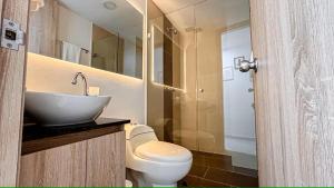 a bathroom with a sink and a toilet and a mirror at Apart De Lujo-Parking-15 minutes Provence in Medellín +19 photos