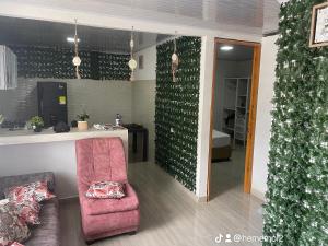 a living room with a pink chair and a counter at La posada in Nuquí