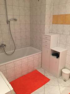 ヴァルヒゼーにあるGrosszügige Wohnung am Waldrandのバスルーム(バスタブ、赤い敷物付) +11枚の写真