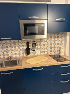 a kitchen with a sink and a microwave at Cappuccino Apartment Sorrento in Sorrento
