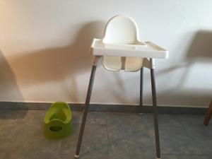 ヴァルヒゼーにあるGrosszügige Wohnung am Waldrandの壁の横にある白いテーブルと緑のスツール