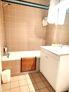 a bathroom with a sink and a tub and a toilet at Chez Soso in Luchon +14 photos